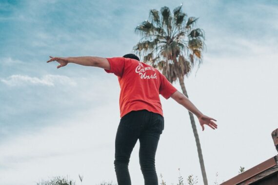 man standing on brown wooden wall during daytime