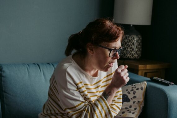 woman in white crew neck t-shirt sitting on gray sofa