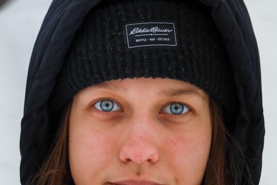 a woman with blue eyes wearing a black hat