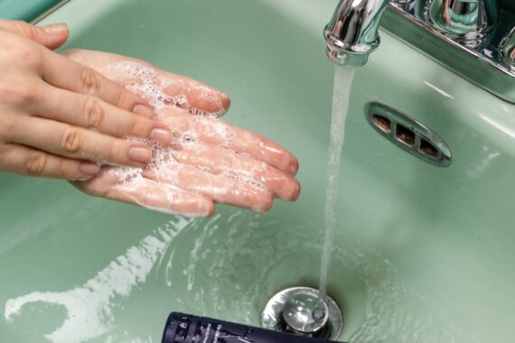 person washing hands on sink
