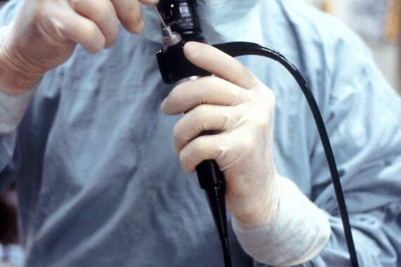 man in blue dress shirt holding black corded device