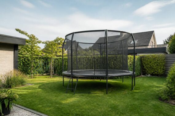 Trampoline met veiligheidsnet in een ruime achtertuin