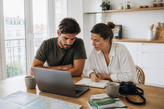 Stel dat vakantieopties vergelijkt op een laptop met notities aan tafel