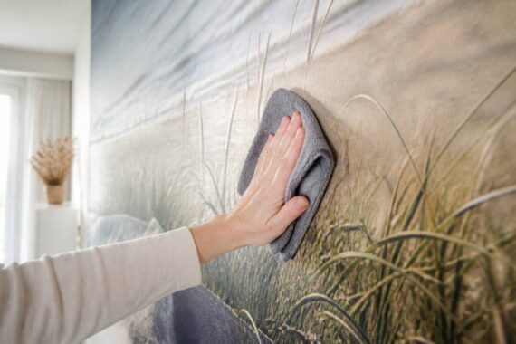 Iemand die fotobehang schoonmaakt met een zachte microvezeldoek
